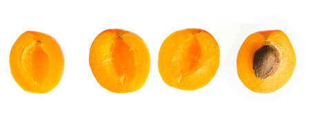Four separate halves of a ripe apricot fruit, on a white backgroundの写真素材