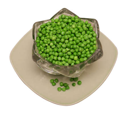green peas separated from the shell, pea seeds, lies in glassware and on a square plate, on a white backgroundの写真素材