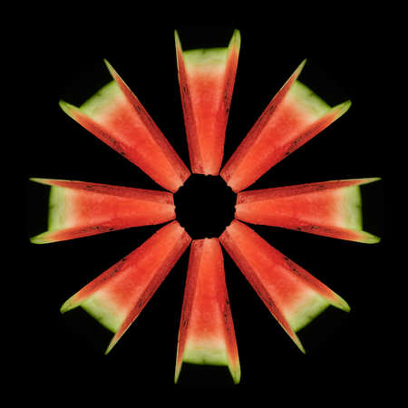 Watermelon cut into equal parts, set in the shape, of a circle on a black background in isolation, view from the topの写真素材