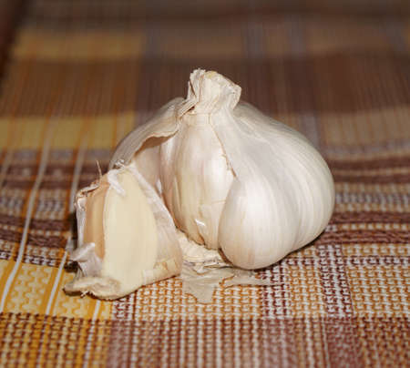 garlic in the husk, on the background of the tableclothの写真素材