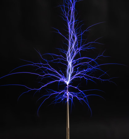 A bright electrostatic discharge with blue branching lightning bolts on a black background.
