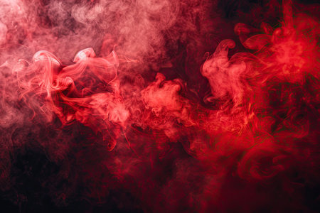A close up of red gas smoke creating a magenta pattern on a black backgroundの素材