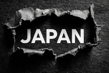 Torn paper art reveals the word JAPAN against a dark backdrop, creating a striking visual effect that symbolizes cultural exploration and discoveryの素材