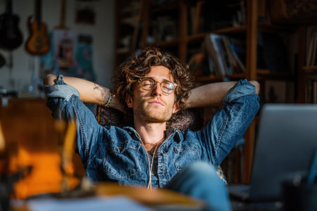 Male with curly hair is comfortably seated in a cozy room, surrounded by books and musical instruments, embodying relaxation and serenity in a warm atmosphereの素材