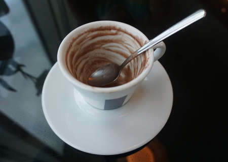 Empty Coffee Cup with a Spoon on a Glass Table at a Hotelのeditorial素材