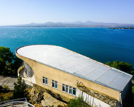 Lake Sevan Shabby 70s Building View with Mountain Peaks in Background