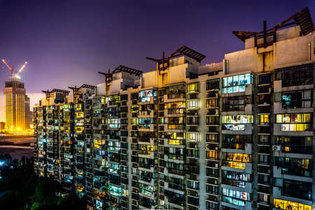 Shanghai Multi Level Highrise Apartment Building with Cloudy Rainy Sky Background at Nightの写真素材