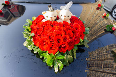 Wedding Heart Shaped Artificial Red Rose Flower Decoration with Two Teddy Bears on a Carの写真素材
