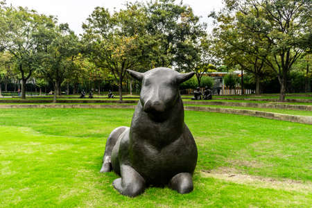 Shanghai Jingan Sculpture Park One Black Bull Sitting on Grassの写真素材
