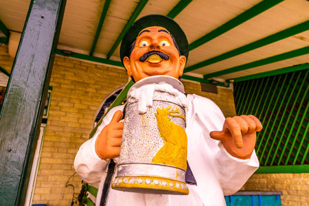 Pefkochori Promenade Street Funny Sculpture of a German Man with Mustache Holding a Beer Jar and Pointing with his Fingerの写真素材