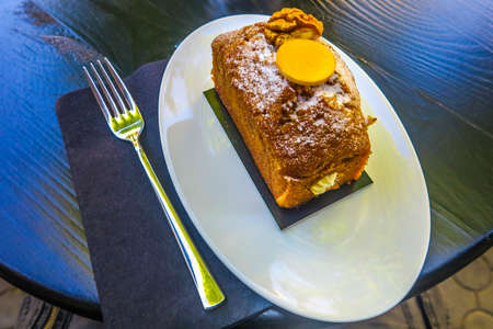 Ukrainian Traditional Carrot Cake with Powder Sugar on a White Oval Plate with a Forkの写真素材