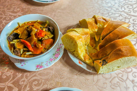 Uzbek Traditional Lagman Noodles Dish with Vegetables and Naan Breadの写真素材