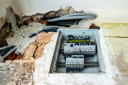 Electrical Power Current Fuse Under Construction with Grey Colored Electricity Lines PVC Hoses Installed in the Wall of an Apartmentの写真素材