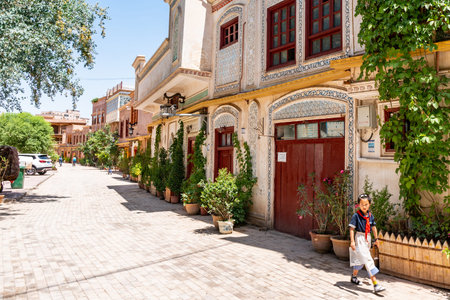Kashgar Renovated Old City Uyghur School Girl is Walking down the Street on a Sunny Blue Sky Day