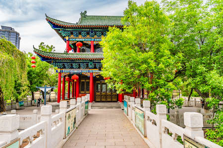 Urumqi Renmin Gongyuan People's Park Breathtaking Lake Pavilion with Skyscrapers at Background on a Sunny Blue Sky Dayの写真素材
