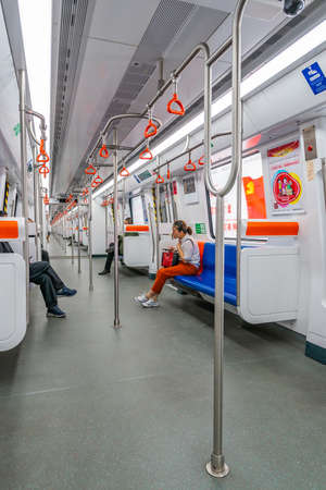 Urumqi Metro Nearly Empty Train with a Few Chinese People Sitting on Blue Colored Seatsのeditorial素材