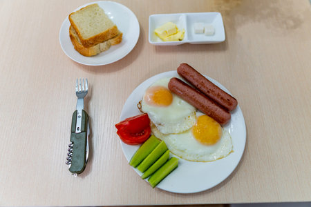 Traditional English Mouthwatering Breakfast with Eggs Sausages Cucumber Tomatoes and a Cup of Coffee