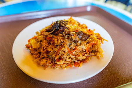 Traditional Kazakhstan Mouthwatering Beef Meat Pilaf with Carrots Served on a White Plate