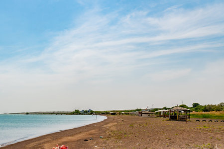 Kapchagay Reservoir Lake Picturesque Breathtaking View of Beach Hut Pavilions on a Sunny Blue Sky Dayの写真素材