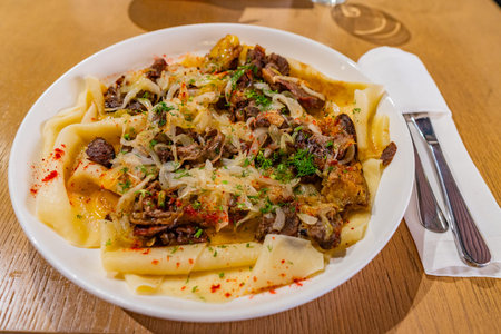 Traditional Kazakhstan Beshbarmak with Flat Noodles Lamb Meat Chopped Onions and Spices on a White...
