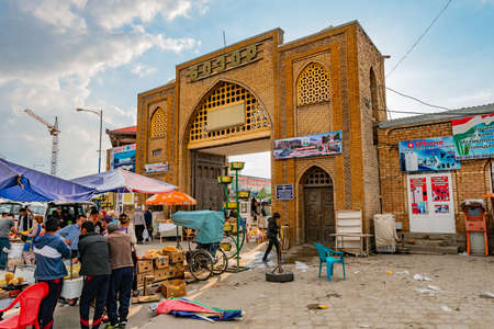 Penjikent Bazaar Entrance Gate Picturesque View with People Selling Goods at Sunset on a Cloudy Blue Sky Dayのeditorial素材