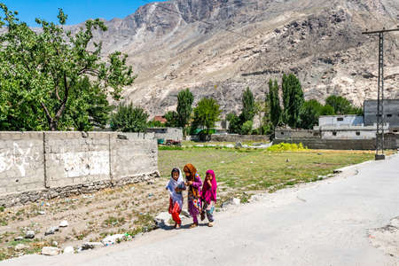 Gilgit Group of Little Girls is Walking at Residential Area Road on a Sunny Blue Sky Dayの写真素材