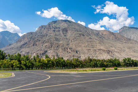 Gilgit Domestic Airport Empty Runway Picturesque View with Mountain on a Sunny Blue Sky Dayの写真素材