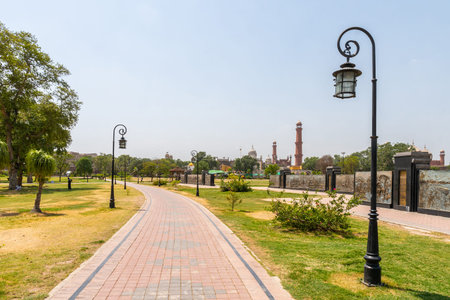 Lahore Iqbal Park Picturesque View with Leading Lines Walkway and Street Lights on a Sunny Blue Sky Dayの写真素材