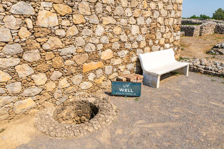 Taxila Ancient Sirkap Picturesque View of a Well and Sitting Bench on a Sunny Blue Sky Dayの写真素材