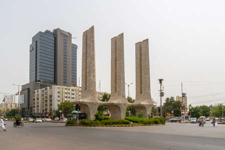 Karachi Teen Talwar Three Swords Monument Ring Road at Khayaban e Iqbal Road with Busy Traffic on a Cloudy Dayのeditorial素材
