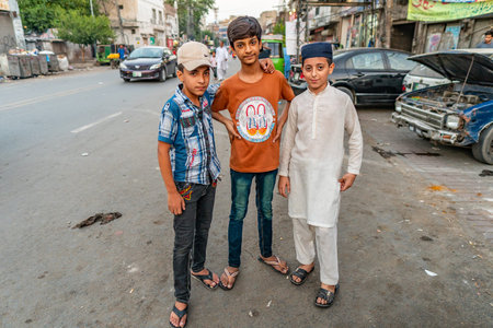 Lahore Three Handsome Little Curious Pakistani Boys Enjoying Taking a Photo at a Common Streetのeditorial素材