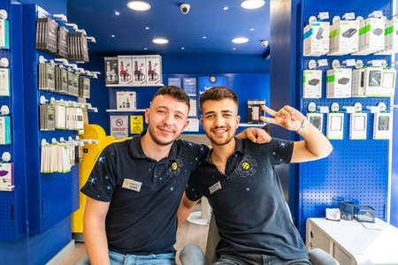 Ankara at Hand Phone Shop two Young Handsome Employees are Sitting and Smilingのeditorial素材