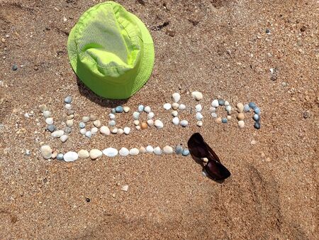 Beautiful Vacation sign formed with the shells and the panama hatの写真素材