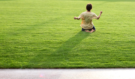 soccer player sliding over grasの写真素材