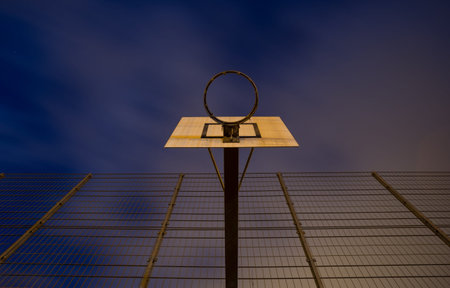 basketball hoop at outdoor court in night skyの写真素材