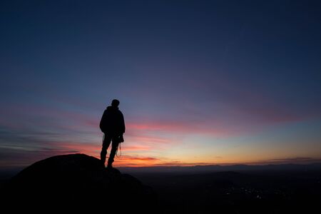 silhouetted photographer in sunset skyの写真素材