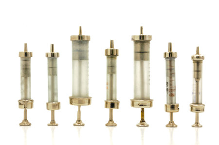 Vintage glass and metal syringes on white background