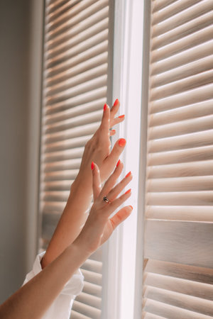 Female hands on a background of a window. Woman waking up stretching in bed at home. Early out morning and wake up rest sunny day. Lifestyle Conceptの写真素材