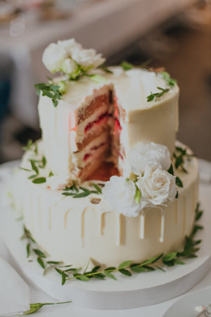 Wedding cake decorated with white roses and green leaves