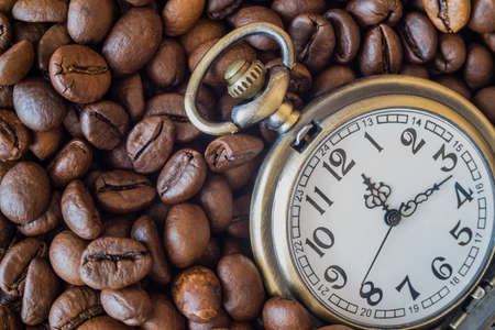 Pocket watch on the background of coffeeの写真素材