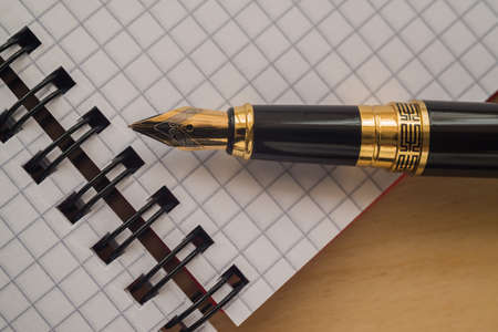 Notebook and pen on a wooden backgroundの写真素材