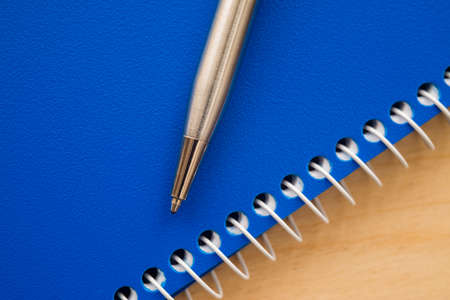 Notebook and pen on a wooden backgroundの写真素材