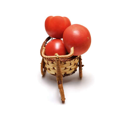 Red tomato in a basket on whiteの写真素材