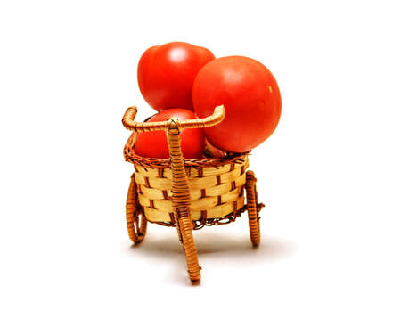 Red tomato in a basket on whiteの写真素材