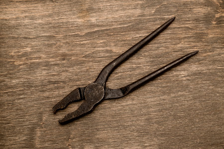 Old pliers on a wooden backgroundの写真素材