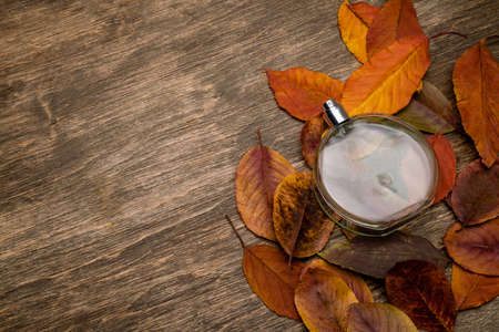 Bottle for perfume on a background of yellow leavesの写真素材