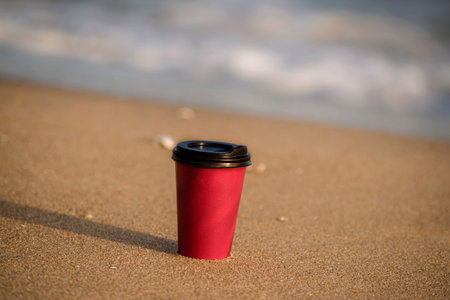 a glass with a coffee on the sand