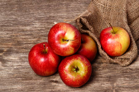 Juicy red apple on an old wooden backgroundの写真素材
