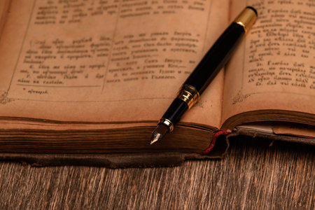 old book and an ink pen on a wooden background.の写真素材