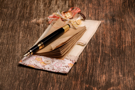Designer notebook and ink pen on a wooden background